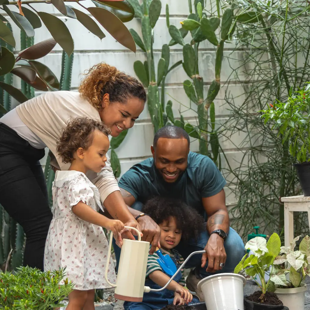Family with young kids outside gardening together