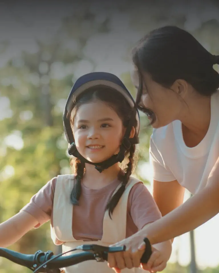 Mother teaching her young daughter to ride a bike