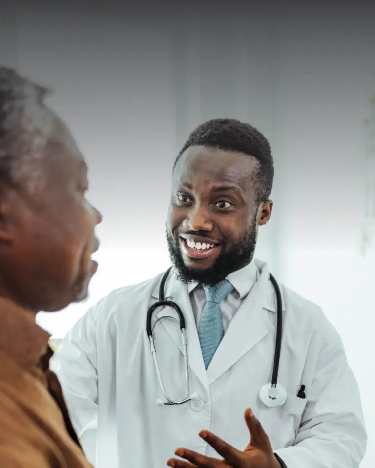 Doctor wearing white lab coat speaking with his patient