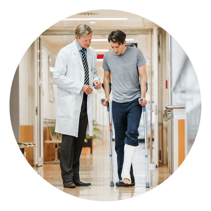 A doctor walking with a patient in a cast