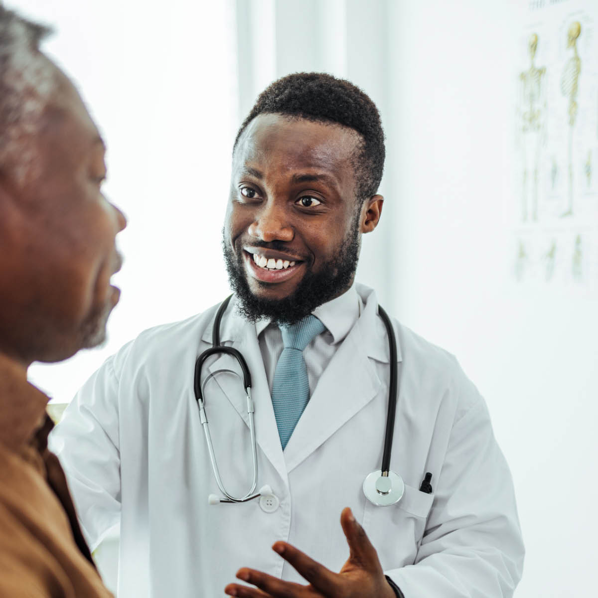 Doctor wearing white lab coat speaking with his patient